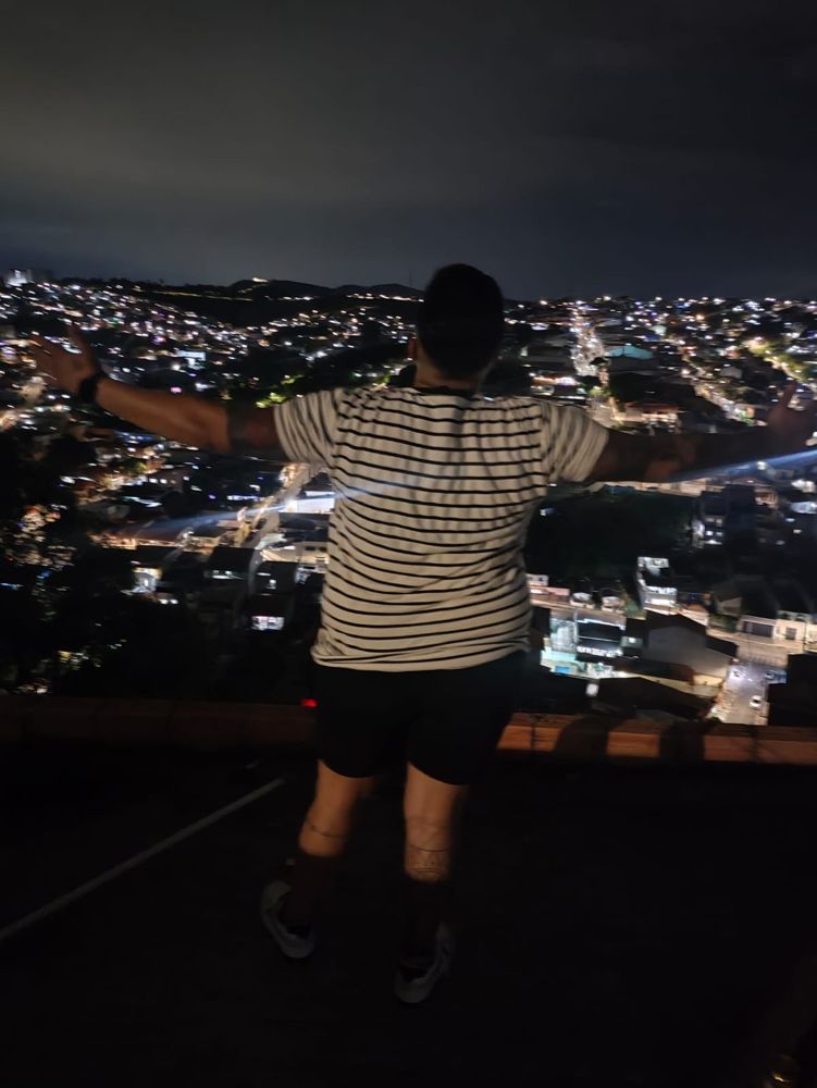 De braços abertos diante da cidade iluminada