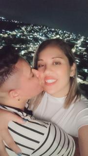 Beijo com a cidade iluminada ao fundo